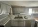 Kitchen with gray cabinets, marble countertops and double sink at 1324 W Bethany Home Rd, Phoenix, AZ 85013