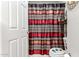 Clean bathroom with red and brown patterned shower curtain at 1340 S 232Nd Ave, Buckeye, AZ 85326