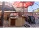 Outdoor kitchen with built-in grill, covered by a patio umbrella at 1340 S 232Nd Ave, Buckeye, AZ 85326