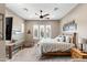 Spacious bedroom featuring a rustic table, ceiling fan, decorative windows, and comfortable furnishings at 1457 E Copper Holw, Queen Creek, AZ 85140