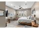 Spacious bedroom featuring a rustic table, ceiling fan, decorative windows, and comfortable furnishings at 1457 E Copper Holw, Queen Creek, AZ 85140