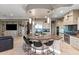 An open kitchen features a curved island with seating, stainless steel appliances, and tiled backsplash at 1457 E Copper Holw, Queen Creek, AZ 85140