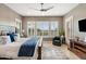 Main bedroom features natural light, a bed with decorative pillows, and gray tile flooring at 1457 E Copper Holw, Queen Creek, AZ 85140