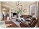 Bright living room with hardwood floors, a leather sectional sofa, and a large flat-screen TV at 1723 E Cotton Ct, Gilbert, AZ 85234