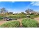 View of a lush golf course with golf carts in the background at 17444 N 79Th St, Scottsdale, AZ 85255