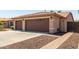 House exterior showcasing a three-car garage and brick pathway at 17925 W Mauna Loa Ln, Surprise, AZ 85388