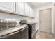 Laundry room with washer, dryer, and upper cabinets at 17925 W Mauna Loa Ln, Surprise, AZ 85388