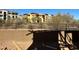 View of a backyard with a retaining wall and a fence looking out at neighborhood buildings at 21048 N 58Th St, Phoenix, AZ 85054