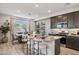 Modern kitchen with a large island, stainless steel appliances, dark cabinets and adjacent dining area at 21048 N 58Th St, Phoenix, AZ 85054