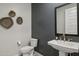 Stylish powder room with pedestal sink and dark accent wall at 21048 N 58Th St, Phoenix, AZ 85054