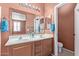 Double vanity bathroom with wood cabinets and a separate toilet area at 2331 W Kristina Ave, San Tan Valley, AZ 85144