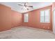 Bedroom with light peach walls, ceiling fan, and window with shutters at 2331 W Kristina Ave, San Tan Valley, AZ 85144