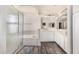 Bright bathroom featuring modern wood floors, white vanity cabinets, and a glass-enclosed shower at 2551 E Saratoga St, Gilbert, AZ 85296