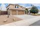 Two-story house with tan exterior, three-car garage, and desert landscaping at 2551 E Saratoga St, Gilbert, AZ 85296