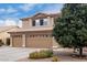 Two-story house with tan exterior, three-car garage, and desert landscaping at 2551 E Saratoga St, Gilbert, AZ 85296