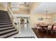 Inviting foyer with elegant staircase, tiled floors, and dining area with wood floors and stylish light fixture at 2551 E Saratoga St, Gilbert, AZ 85296