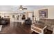 Open-concept living room with hardwood flooring, neutral-toned furniture, and views into the kitchen area at 2551 E Saratoga St, Gilbert, AZ 85296