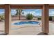 Back patio with unique pool surrounded by desert landscaping, as seen from under the patio covering at 2551 E Saratoga St, Gilbert, AZ 85296