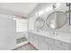 Elegant bathroom with double vanity, large mirror, and walk-in shower at 2605 N 133Rd Ave, Goodyear, AZ 85395