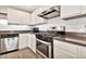 Kitchen with stainless steel stove, oven, and range hood, plus white cabinets at 2626 S Southwind Dr, Gilbert, AZ 85295