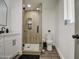 Modern bathroom with a glass shower, white cabinets, and wood-look floors at 3530 W Marlette Ave, Phoenix, AZ 85019