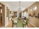 Dining area with a glass-top table and four green leather chairs at 41604 N Cedar Chase Rd, Anthem, AZ 85086