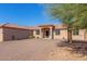 Single-story home with Spanish-style architecture, gravel driveway, and mature trees at 44429 N 1St Dr, New River, AZ 85087