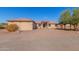 Single-story home with Spanish-style architecture, gravel driveway, and mature trees at 44429 N 1St Dr, New River, AZ 85087