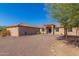 Single-story home with Spanish-style architecture, gravel driveway, and mature trees at 44429 N 1St Dr, New River, AZ 85087