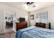 Well-lit bedroom with a decorative blue patterned bedspread and a glimpse into dining area at 4511 W Valencia Dr, Laveen, AZ 85339