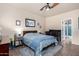 Well-lit bedroom featuring a cozy queen-sized bed, ceiling fan, and a black crib at 4511 W Valencia Dr, Laveen, AZ 85339