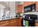 Kitchen featuring wood cabinets, granite counters and black appliances at 4511 W Valencia Dr, Laveen, AZ 85339