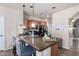 Kitchen island featuring a granite countertop, seating, and pendant lighting at 4511 W Valencia Dr, Laveen, AZ 85339