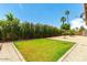 Landscaped backyard with grassy area, and mature shrubs at 4543 W Lane Ave, Glendale, AZ 85301