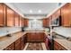 Galley kitchen with wood cabinets, granite counters, and stainless steel appliances at 4543 W Lane Ave, Glendale, AZ 85301