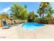 Relaxing kidney-shaped pool, patio furniture, and umbrella at 4543 W Lane Ave, Glendale, AZ 85301