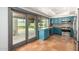 Modern kitchen with teal cabinets, stainless steel appliances, and terracotta tile floors at 4622 E Palo Verde Dr, Phoenix, AZ 85018