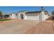 Exterior view of a single-story house with a two-car garage and a neatly landscaped yard at 5919 S Lakeshore Dr, Tempe, AZ 85283