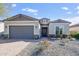 Single-story home with gray exterior, two-car garage, and landscaped front yard at 5933 N 189Th Dr, Litchfield Park, AZ 85340