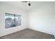 Simple bedroom with grey carpet, ceiling fan and large window at 6118 N 183Rd Ave, Waddell, AZ 85355