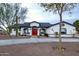 White single-story home with red door, gray roof, and landscaped yard at 6118 N 183Rd Ave, Waddell, AZ 85355