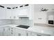 Modern kitchen with white cabinets, marble countertops, and a built in range at 6118 N 183Rd Ave, Waddell, AZ 85355