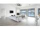 Bright living room with grey tile floors, white sofa, and pool view at 6118 N 183Rd Ave, Waddell, AZ 85355