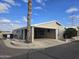 Tan mobile home with carport and mature palm tree in front at 650 N Hawes Rd # 4820, Mesa, AZ 85207