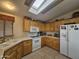 Bright kitchen with wood cabinets, skylights, and white appliances at 650 N Hawes Rd # 4820, Mesa, AZ 85207