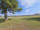 View of a green grassy area with mature trees and homes in the background at 650 N Hawes Rd # 4820, Mesa, AZ 85207