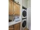 Stackable washer and dryer in a well-lit laundry room with wood cabinets at 650 N Hawes Rd # 4820, Mesa, AZ 85207