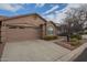 Tan two-car garage home with landscaping and a paved driveway at 6610 E University Dr # 157, Mesa, AZ 85205