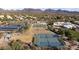 Scenic community aerial view with tennis and basketball courts, sand volleyball, and solar panels against a mountain backdrop at 7654 E Quill Ln, Scottsdale, AZ 85255