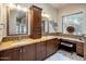 Bathroom featuring granite countertops, dual sinks, wooden cabinets, decorative mirrors and a vanity at 7654 E Quill Ln, Scottsdale, AZ 85255